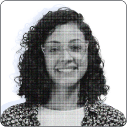 A imagem mostra uma mulher sorridente, de cabelos cacheados e óculos, vestindo uma camisa estampada. A foto é em preto e branco, tem efeito pixelizado, fundo claro e bordas arredondadas.